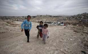 Des enfants bédouins pieds nus courent sur un chemin, le 22 octobre 2014 aux environs de Jérusalem