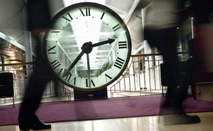 Des personnes passent devant une horloge, le 25 Mars 2010 au centre commercial de la Toison d'Or à Dijon.