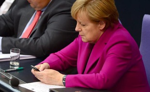 La chancelière allemande Angela Merkel consulte son téléphone portable le 4 juin 2014 lors d'une session parlementaire à Berlin