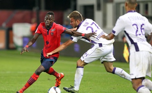 Le Toulousain Alexis Blin tente d'arrêter l'Ajaccien Issiaga Sylla sous les yeux de Marcel Tisserand.