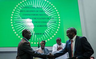 Chief of staff of the Ethiopian Armed Forces and Field Marshal Berhanu Jula (L) shakes hands with Commander-in-chief of the Tigray rebel forces General Tadesse Worede (R) as, former Nigeria's President Olusegun Obasanjo (CL) and former Kenya's President Uhuru Kenyatta (CR) applaud during the signing ceremony of the declaration of the senior commanders meeting on the implementation of the Ethiopia permanent cessation of hostilities agreement between the government of Ethiopia and the Tigray People's Liberation Front (TPLF) in Nairobi on November 12, 2022. - The restoration of desperately needed humanitarian assistance to the region is one of the key planks of a peace deal between the federal government and the Tigray People's Liberation Front (TPLF) to end two years of brutal war in northern Ethiopia. (Photo by Yasuyoshi CHIBA / AFP)