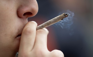 (FILES) In this file photo taken on May 12, 2018 a man smokes a joint during a demonstration for the decriminalization of cannabis in France, in Paris. - Starting from November 19, 2018 French deputies will examine the new draft-law concerning the justice reform. Among the points raised : the creation of a fixed fine of 200 euros in case of cannabis use. (Photo by Thomas SAMSON / AFP)