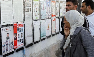 Des Tunisiens jettent un oeil aux listes électorales, dans le centre de Tunis, le 22 ocotbre 2011.