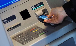 Une personne insère sa carte bleue dans un distributeur de billets, le 29 octobre 2008 à Paris.
