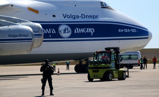 Un gendarme armé devant l'avion acheminant en France des millions de masques médicaux