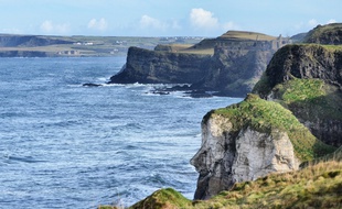 Sur la côte d'Antrim, le géant Finn McCool semble toujours regarder en direction de l'Écosse. Sa fameuse Chaussée n'est qu'à quelques kilomètres de là.