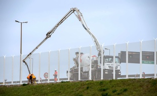 Des ouvriers installent le corridor sécurisé au port de Calais.