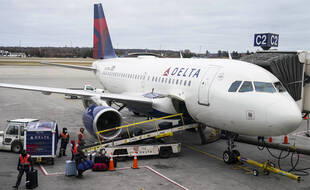 Des employés déchargent une cargaison de masques d'un avion de la compagnie Delta, le 12 décembre 2020, à l'aéroport Saint Paul de Minneapolis.