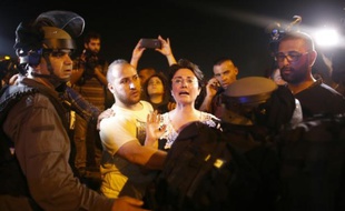 La députée arabo-israélienne Haneen Zoabi se débat le 16 août 2015 à Ashkelon (sud) avec des policiers israéliens lors d'une manifestation de soutien à Mohammed Allan, un détenu palestinien tombé dans le coma après deux mois de grève de la faim