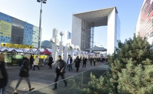 Des gens marchent près de la Grande arche de La Défense, quartier d'affaires de Paris, le 9 décembre 2015.