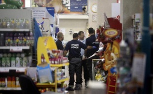 Des policiers israéliens dans les allées du supermarché de la colonie israélienne de Mishor Adumim, en Cisjordanie le 3 décembre 2014