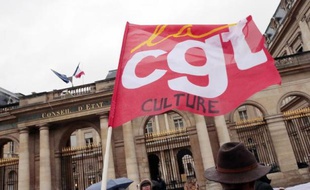 Des manifestants munis d'un drapeau de la CGT devant le Conseil d'Etat à Paris le 19 décembre 2014 veulent défendre une politique culturelle ambitieuse