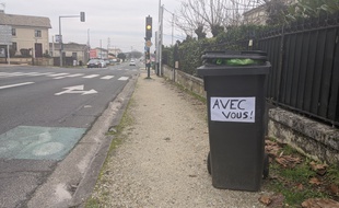 Ces habitants affichent leur soutien aux éboueurs.