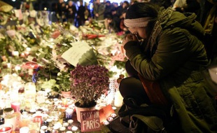 Des personnes se recueillent devant le Bataclan, en hommage aux victimes des attentats, le 15 novembre 2015 à Paris