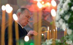 Le président russe, Vladimir Poutine, brûle un cierge dans une église de Pouchkine, près de Saint-Pétersbourg, le 8 décembre 2014.