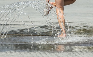 Illustration: Des gens se rafraîchissent près d'une fontaine, le 27 juillet 2018.