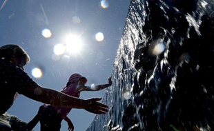 Une petite fille se rafraîchit dans une fontaine du parc Manezhnaya de Moscou, le 14 Mai 2013.