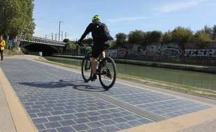 L'énergie produite par les dalles photovoltaïques permettent d’éclairer, en journée, la portion de piste cyclable qui passe sous un pont, à quelques mètres de là.