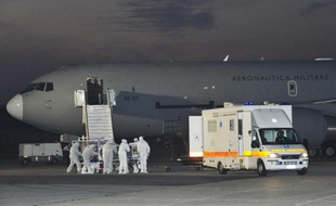 Une ambulance vient chercher le médecin italien contaminé par le virus Ebola au pied de l'avion de l'armée italienne qui l'a transporté depuis la Sierra Leone, le 25 novembre 2014 à l'aéroport Pratica di Mare, près de Rome