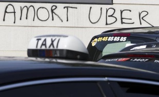Un graffiti hostile à Uber, alors que des chauffeurs de taxi manifestent près de la Porte Maillot, à Paris, le 29 juin 2015