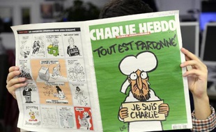 Un homme lit le dernier numéro de Charlie Hebdo à Paris le 13 janvier 2015