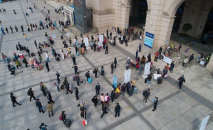 Des passagers font la queue pour entrer dans la gare de Hankou à Wuhan, dans la province centrale du Hubei en Chine, le 8 avril 2020.