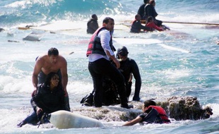 Des hommes viennent en aide à des migrants après un naufrage au large de Rhodes en Grèce, le 20 avril 2015