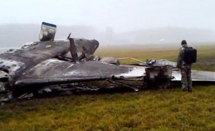 Un secouriste devant l'épave du Falcon 50 du PDG de Total Christophe de Margerie sur l'aéroport de Vnukovo, à Moscou, le 21 octobre 2014