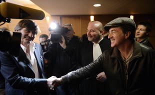 Former police officer Michel Neyret (L) shakes hand with French actor Francois Cluzet (R) upon their arrival at Lyon's courthouse, on December 16, 2014, prior to a hearing regarding a libel suit against Cluzet for his purpose on Neyret. Cluzet said in a press conference in March 2013 that Neyret "might have stolen the loot of Tony Musulin", a former security van driver known for having stolen 11.6 million euros from the Banque de France while on duty. AFP PHOTO/PHILIPPE DESMAZES