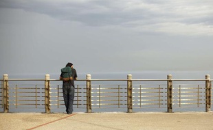 Homme sur une promenade en front de mer.