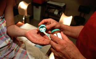 Un gynécologue donne une pilule abortive à une jeune fille.