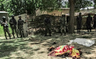 Des membres de la sécurité camerounaise devant la dépouille d'une victime d'un attentat suicide à Kolofata, dans l'extrême nord du Cameroun, le 13 septembre 2015