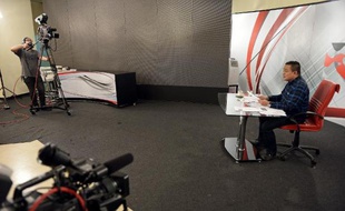 TO GO WITH 'THAILAND-POLITICS-OPPOSITION' by Delphine THOUVENOT Jatuporn Prompan, président des Chemises rouges, lors d'une émission en direct dans les studios de Peace TV à Bangkok le 10 octobre 2014