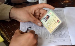 Vérification de l'identité d'un électeur, dans un bureau de vote de Kaboul le 5 avril 2014
