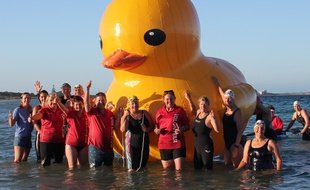 Le Cockburn Masters Swimming Club et des nageurs posent avec leur mascotte, Daphne, le canard gonflable géant.