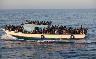 Avril 2011. Des immigrés sub-sahariens arrivent dans une embarcation près des cotes de l'île italienne de Lampedusa, en Méditerrannée.
