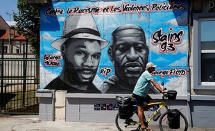 Un homme passe devant la fresque du Collectif Art, à Stains.