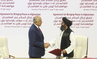 Zalmay Khalilzad et Mullah Abdul Ghani Baradar se serrent la main après la signature de l'accord, à Doha, au Qatar, le 29 février 2020.