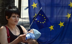 Une femme tient son bébé dans les bras et un drapeau européen, le jour de la fête de l'Europe à Marseille, le 9 mai 2012