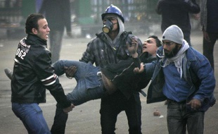 Des manifestants égyptiens évacuent l'un des leurs, blessés dans les heurts qui les opposent aux forces de l'ordre, le 17 décembre 2011, au Caire.