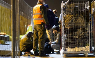 Des migrants attendent d'embarquer dans un bus à Sentilj (Slovénie), le 17 octobre 2015 pour les conduire en Autriche