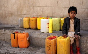 Un enfant attend la distribution d'eau potable au Yémen.