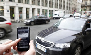 Utilisation de l'application Uber sur smartphone pour réserver un voiture avec chauffeur, à Paris le 10 décembre 2014