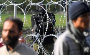 Un garde-frontière polonais surveille un camp de réfugiés derrière des barbelés installés à la frontière entre la Biélorussie et la Pologne près du village d'Usnarz Dolny, en Biélorussie.