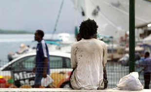 Un homme est assis sur le quai de la Darse le 05 décembre 2003 à Pointe-à-Pitre en Guadeloupe.