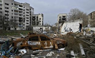 A local resident past a graffiti on a wall of destroyed building, drawn in Banksy style but its origin unconfirmed by the artist, in the town of Borodyanka on November 12, 2022, amid the Russian invasion of Ukraine. - Banksy, the elusive British street artist, has painted a mural on a bombed-out building outside Ukraine's capital, in what Ukrainians have hailed as a symbol of their country's invincibility. On November 11's night the world-famous graffiti artist posted on Instagram three images of the artwork -- a gymnast performing a handstand amid the ruins of a demolished building in the town of Borodyanka northwest of the Ukrainian capital Kyiv. (Photo by Genya SAVILOV / AFP) / RESTRICTED TO EDITORIAL USE - MANDATORY MENTION OF THE ARTIST UPON PUBLICATION - TO ILLUSTRATE THE EVENT AS SPECIFIED IN THE CAPTION
