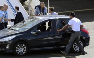 Le juge d'instruction de Mayotte Hakim Karki (3e d) arrive sous escorte policière le 7 juillet 2014 à l'aéroport Sainte-Marie de La Réunion