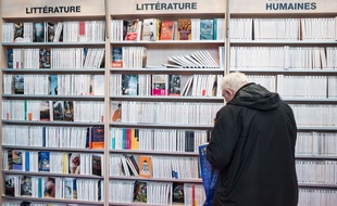 Un homme, devant des livres (Illustration).