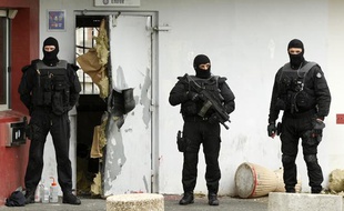 Des enquêteurs devant une porte de la prison de Sequedin détruite à l'explosif lors de l'évasion de Rédoine Faïd, le 13 avril 2013.