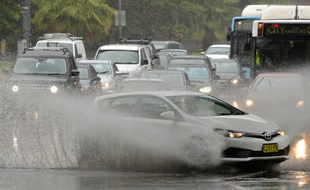 Des voitures roulent dans une rue inondée à Sydney, le 28 novembre 2018.